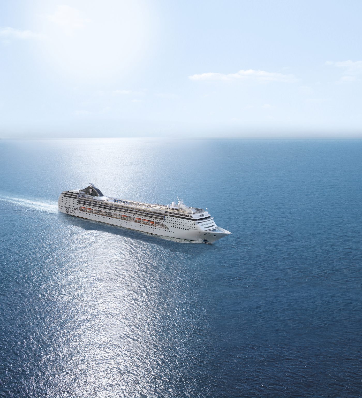MSC Opera aus der Luft, in Fahrt auf tiefblauem Meer im Glitzern der Sonne