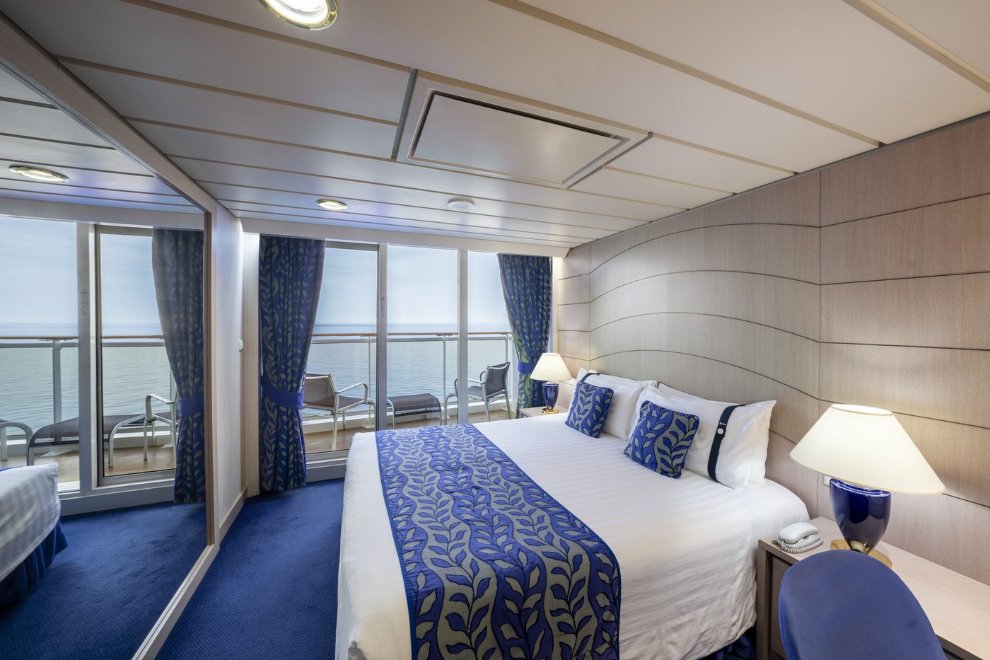 Balkonkabine mit Doppelbett und Blick aufs Meer